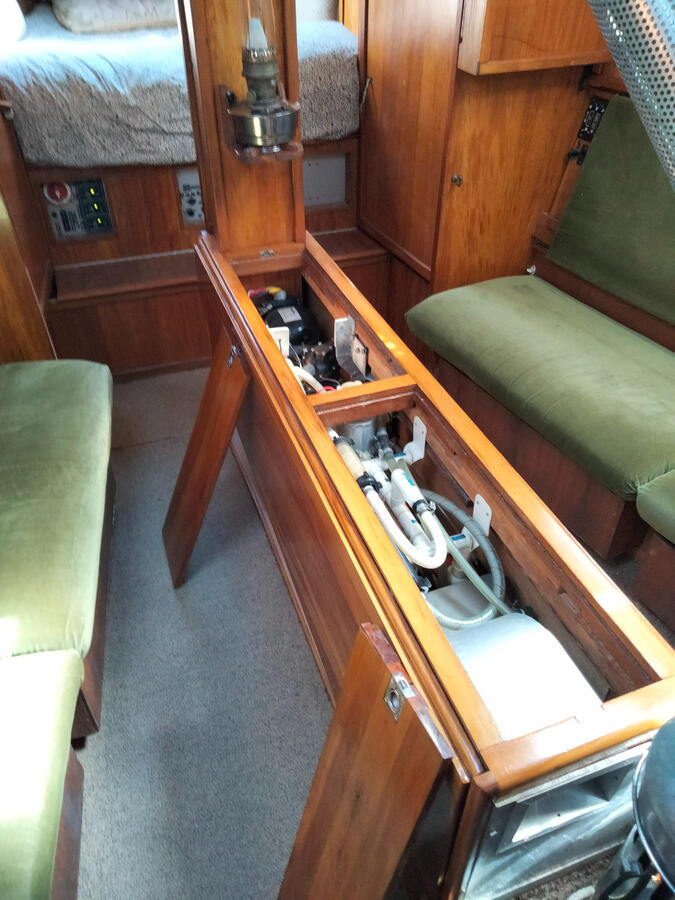 Refrigeration compresssors, plumbing manifolds and hot water calorifier within table spine Refrigeration compresssors, plumbing manifolds and hot water calorifier within table spine